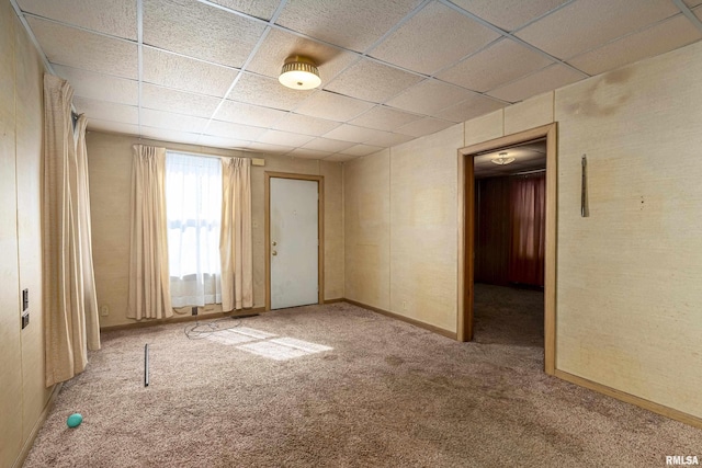 carpeted spare room with a paneled ceiling