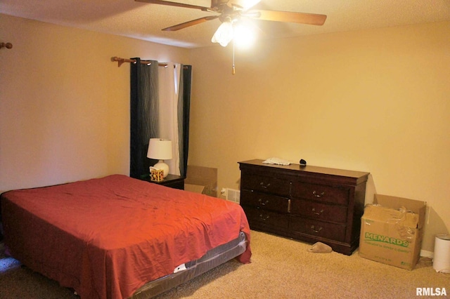 carpeted bedroom featuring a ceiling fan and visible vents