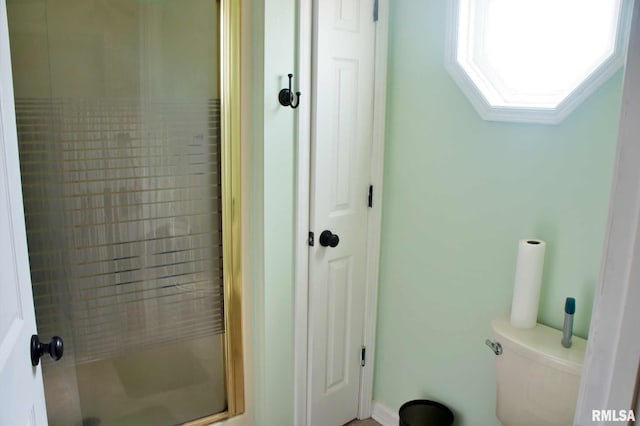 full bathroom with a stall shower, a skylight, and toilet