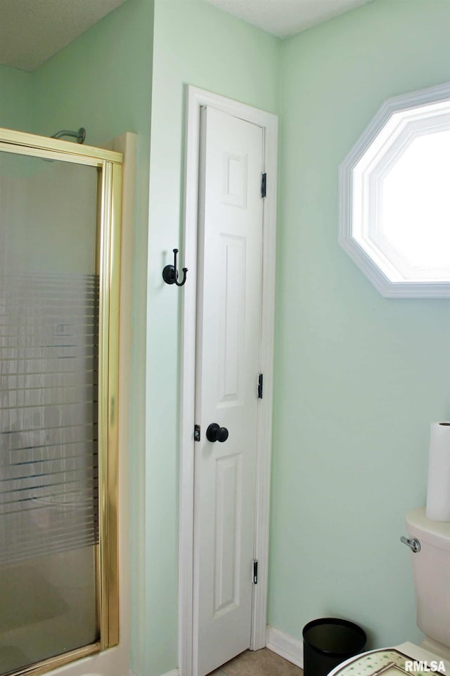 bathroom with toilet and a stall shower