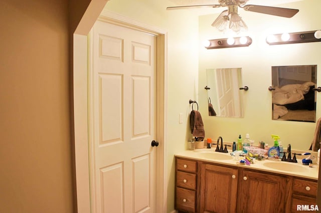 bathroom with ceiling fan, a sink, and double vanity