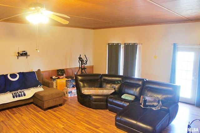 living room featuring a wainscoted wall, a ceiling fan, and wood finished floors