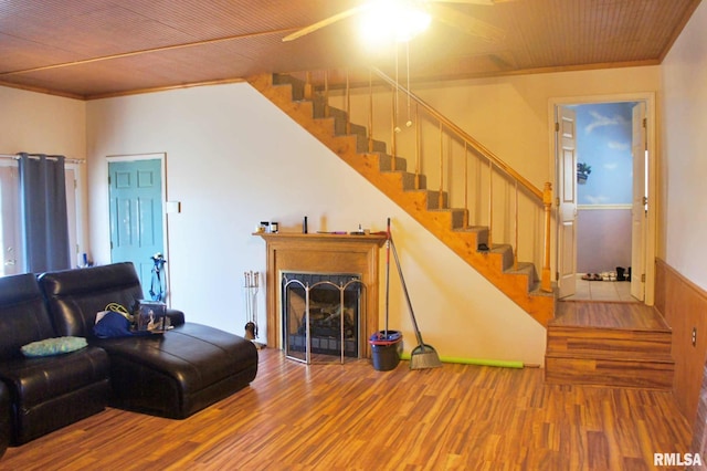 living area featuring crown molding, a fireplace, stairway, wood ceiling, and wood finished floors