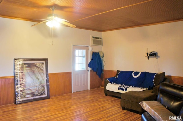 living room featuring wood ceiling, wainscoting, wooden walls, wood finished floors, and a wall mounted air conditioner