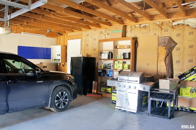 garage with a garage door opener and freestanding refrigerator