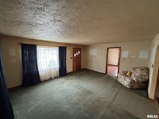 unfurnished living room with carpet flooring and a textured ceiling