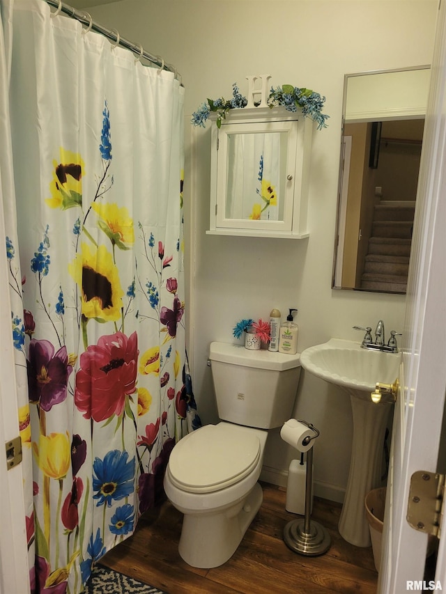 full bath featuring toilet, baseboards, wood finished floors, and a shower with shower curtain