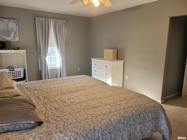 carpeted bedroom with ceiling fan and baseboards