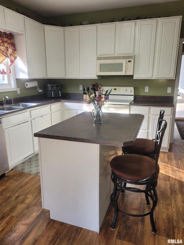 kitchen with dark countertops, white microwave, electric range, and dark wood-style flooring