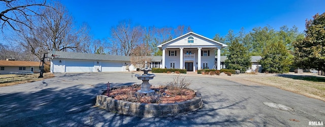 neoclassical home featuring a garage and driveway