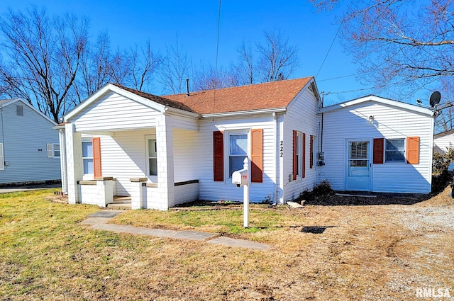 bungalow-style home with a shingled roof and a front yard