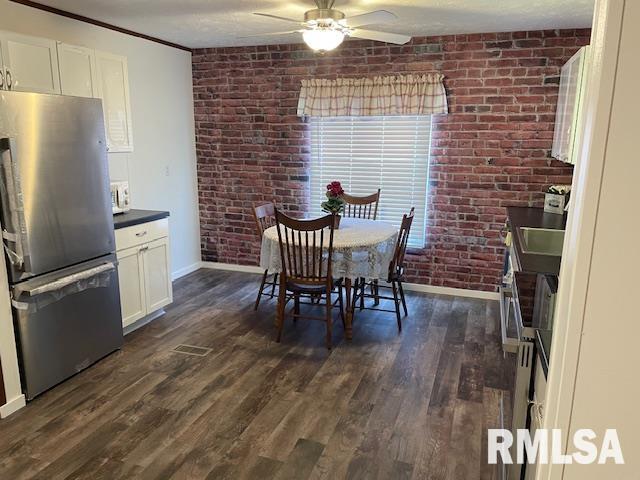 24555 Rock Springs Hollow Rd, Thebes, IL 62990 - dining area with baseboards, ceiling fan, brick wall, and dark wood-type flooring