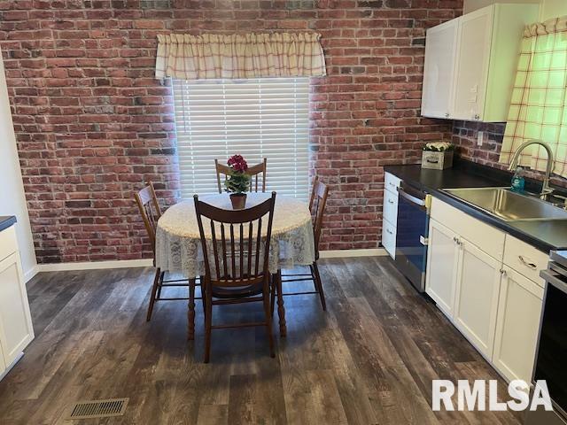 24555 Rock Springs Hollow Rd, Thebes, IL 62990 - dining room featuring baseboards, dark wood-type flooring, and brick wall