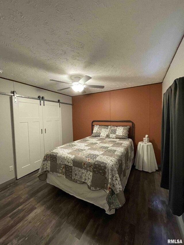 24555 Rock Springs Hollow Rd, Thebes, IL 62990 - bedroom with wood finished floors, a barn door, ceiling fan, and a textured ceiling