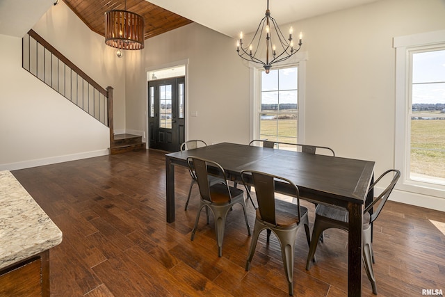 dining room featuring stairway, dark wood finished floors, a wealth of natural light, and an inviting chandelier