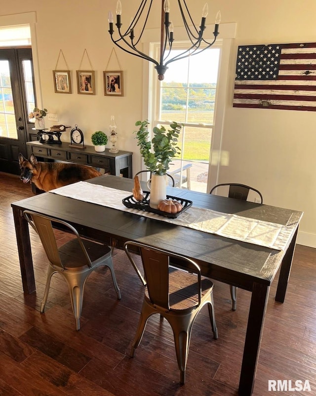 dining space with an inviting chandelier, baseboards, and wood finished floors