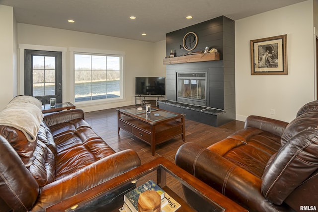 living area with recessed lighting, a fireplace, baseboards, and wood finished floors