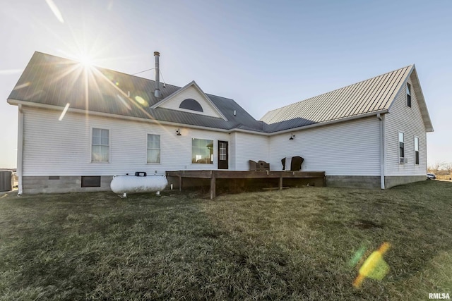 back of property with a yard, crawl space, metal roof, and central AC unit