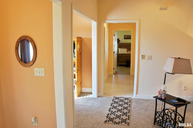 hallway with baseboards and carpet flooring