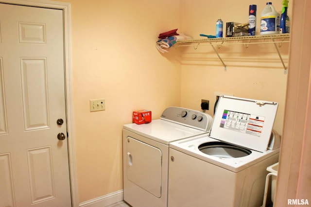 laundry area featuring laundry area, washing machine and dryer, and baseboards