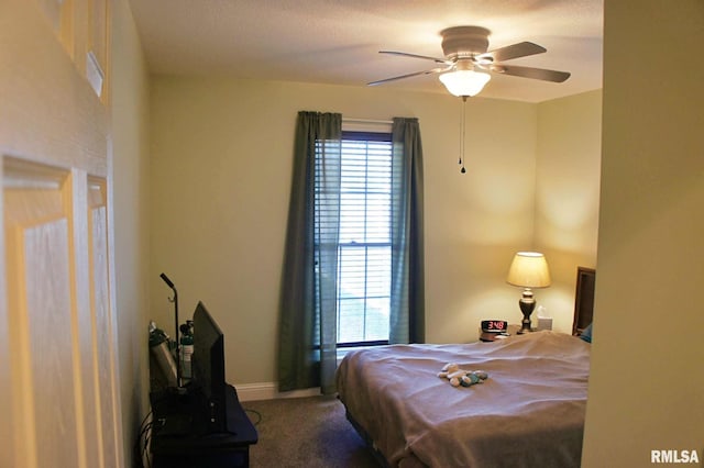 carpeted bedroom featuring multiple windows, baseboards, and a ceiling fan