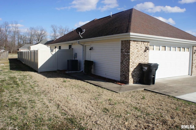 view of side of home with driveway, a garage, roof with shingles, fence, and brick siding