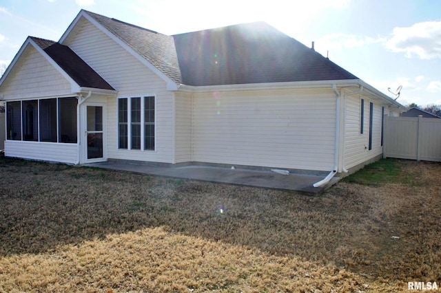 back of house with a patio, a shingled roof, a lawn, a sunroom, and fence