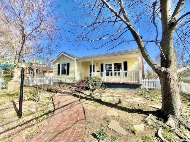 view of front of home with covered porch and fence