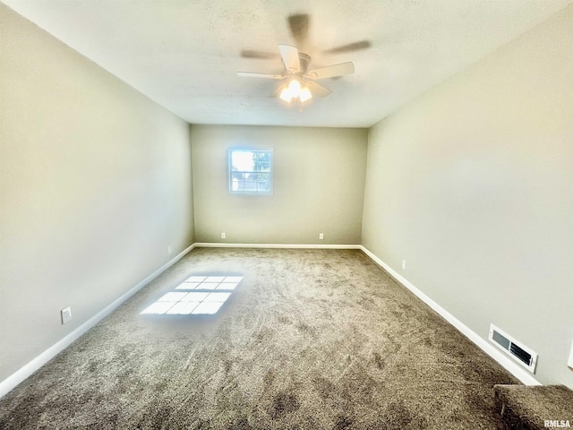 carpeted empty room with baseboards, visible vents, and a ceiling fan