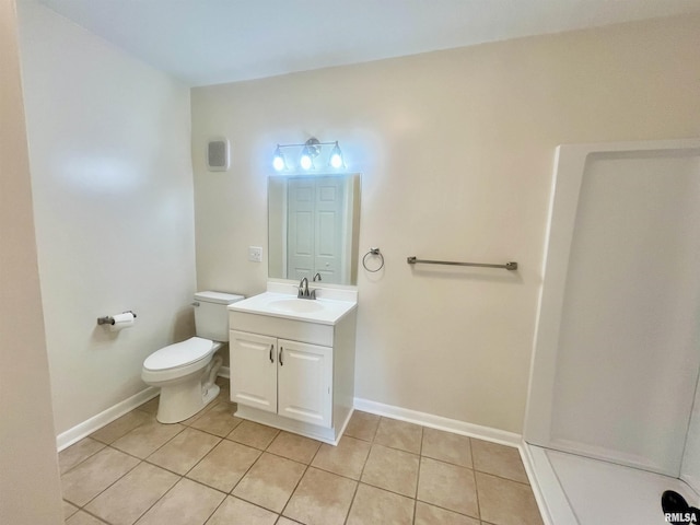 bathroom with toilet, vanity, baseboards, and tile patterned floors