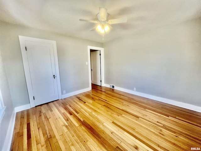 unfurnished bedroom with ceiling fan, light wood-style flooring, visible vents, and baseboards