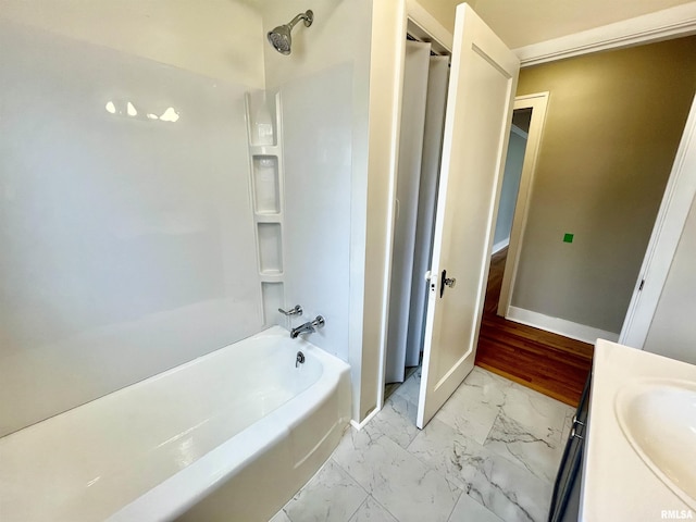 full bath with shower / washtub combination, marble finish floor, a sink, and baseboards