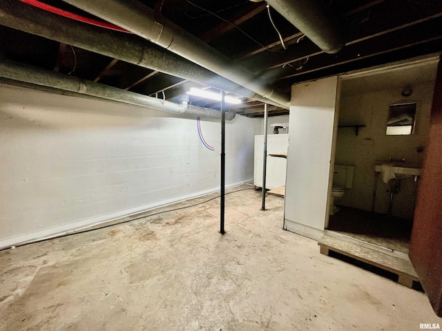 unfinished basement featuring washer / dryer