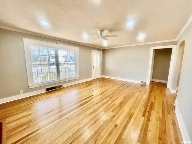 unfurnished living room featuring light wood-style floors, visible vents, and ornamental molding