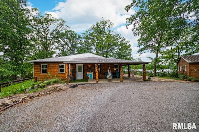 view of front of house featuring driveway, metal roof, and an attached carport