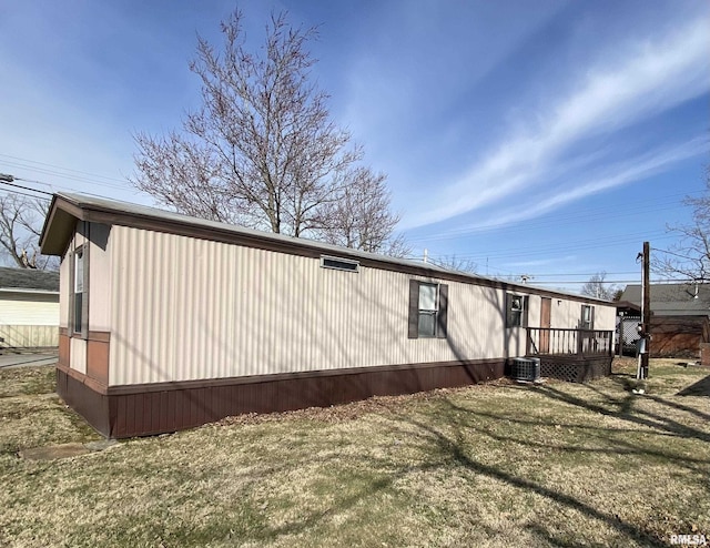 view of side of property with cooling unit and a yard