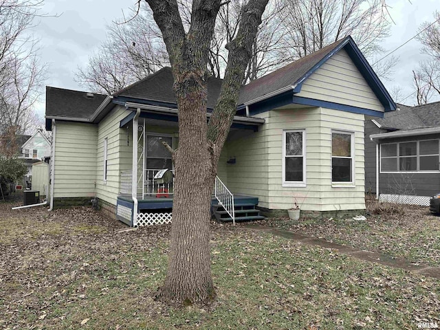 back of property featuring a shingled roof and central AC unit