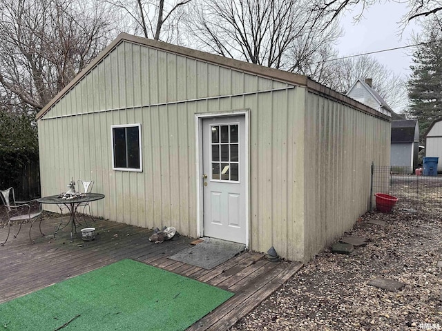 view of outbuilding featuring fence and an outbuilding