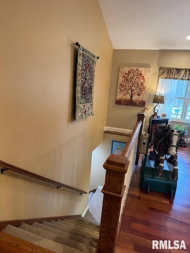 stairs featuring vaulted ceiling and wood finished floors