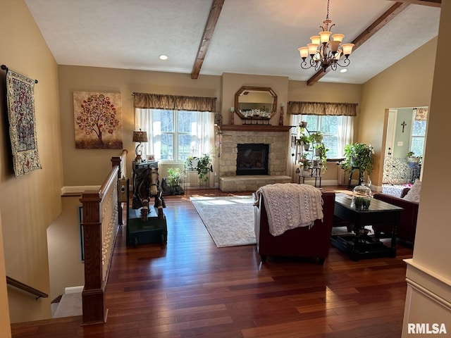 living area with a stone fireplace, a healthy amount of sunlight, an inviting chandelier, and dark wood-style flooring