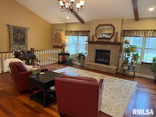 living area featuring a wealth of natural light, a stone fireplace, vaulted ceiling with beams, and wood finished floors