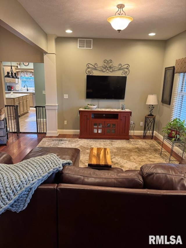 living area with recessed lighting, wood finished floors, visible vents, and baseboards