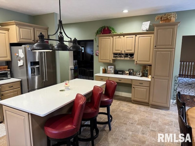 kitchen featuring built in desk, a center island, stainless steel refrigerator with ice dispenser, and light countertops