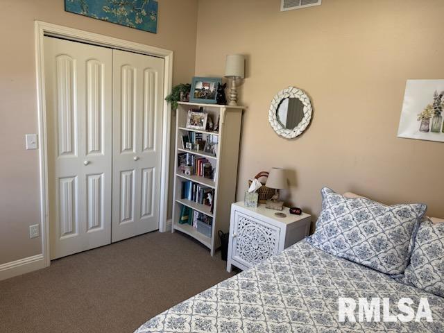 carpeted bedroom with a closet, visible vents, and baseboards