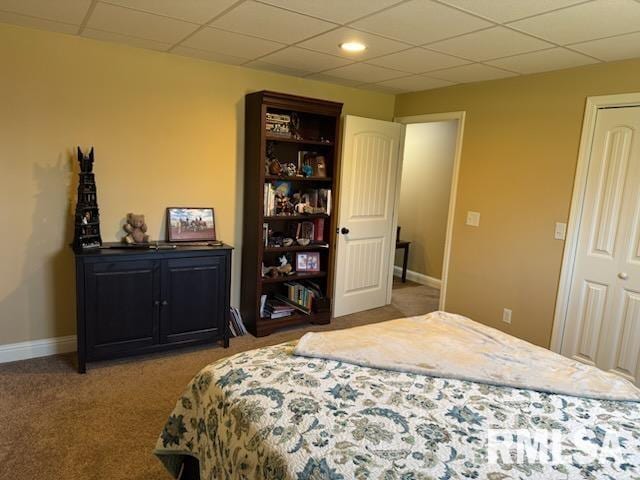 bedroom featuring a drop ceiling, baseboards, and carpet floors