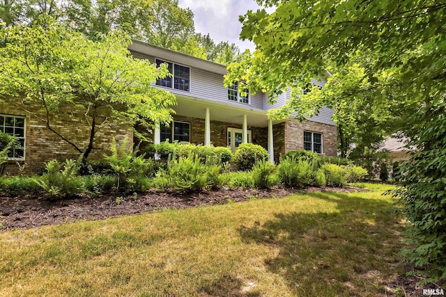 view of front of property featuring brick siding and a front yard