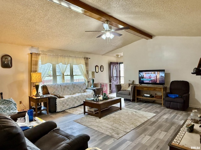 living room featuring vaulted ceiling with beams, ceiling fan, a textured ceiling, and wood finished floors