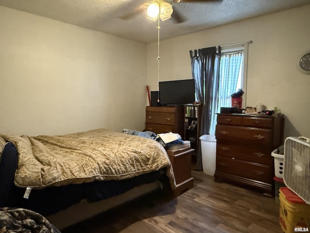 bedroom with a ceiling fan, dark wood finished floors, and a textured ceiling