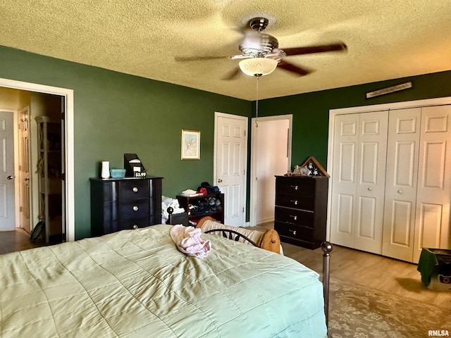 bedroom featuring a textured ceiling, ceiling fan, a closet, and wood finished floors