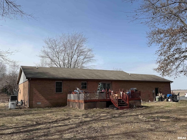 rear view of property with a deck, brick siding, crawl space, and central air condition unit